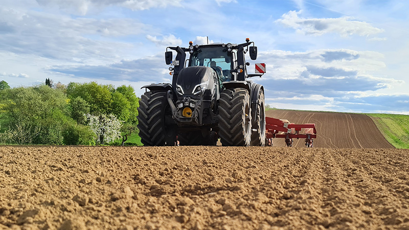 Valtra Traktor der T-Serie in Schwarzmetallic mit Reifendruckregelanlage und Einzelkornsämaschine. 