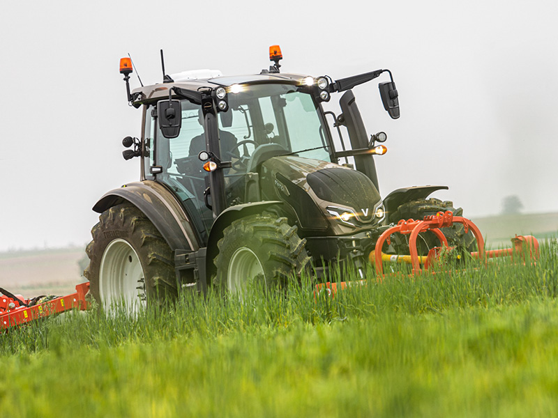 Traktor Valtra G135 mit Front- und Heckmähwerk im Grünland