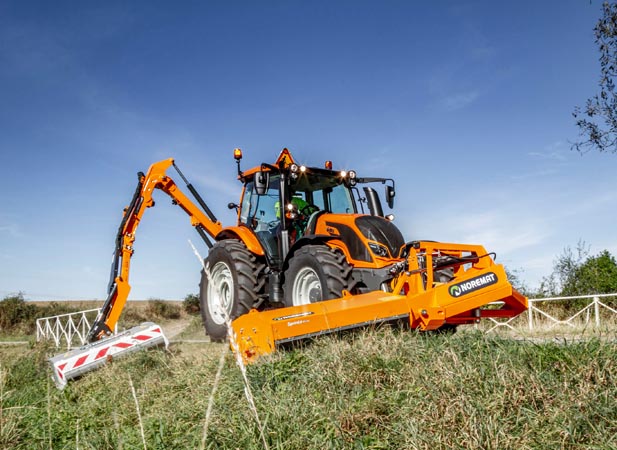 Valtra Traktor mit Noremat Mähauslegern