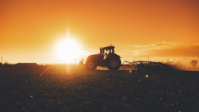 Traktor der Valtra Q-Serie mit Grubber im Sonnenuntergang